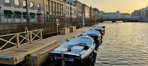 a row of boats docked at a dock in the water at Husbåten Vega 2 Göteborg City in Gothenburg