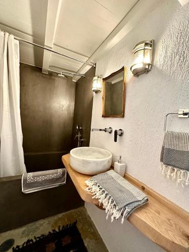 a bathroom with a white sink and a mirror at Olive Mill Cottage in Skopelos Town
