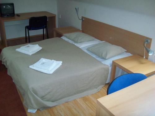 a bedroom with a bed with two towels on it at hotel U lip Trojanovice in Frenštát pod Radhoštěm