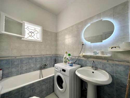 a bathroom with a washing machine and a sink at Dar almasyaf, maison bord de mer in Gabès