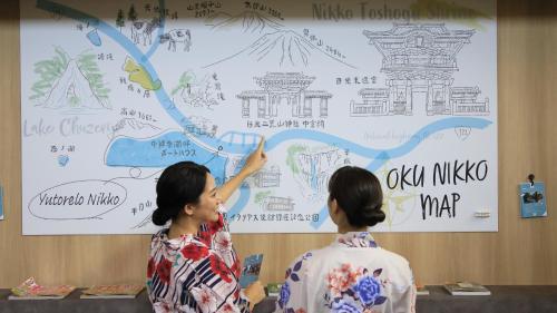 two women are standing in front of a large wall at Yutorelo Nikko in Nikko