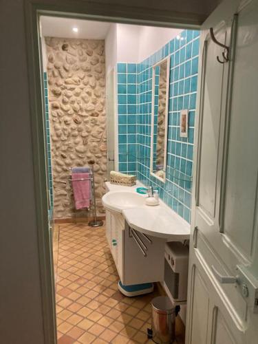 a bathroom with a sink and a mirror and blue tiles at La Célestine in Valensole