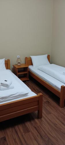 two beds sitting next to each other in a room at Prenoćište Dajević Hotel Tara Pljevlja in Pljevlja