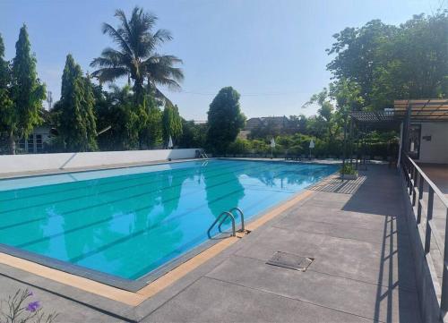 a large swimming pool with blue water at Baan Mali Apartment in Chiang Mai