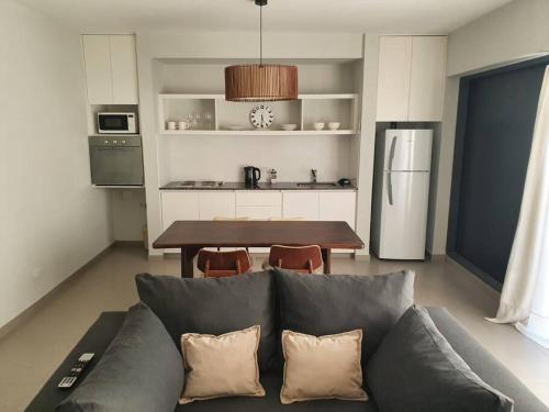 uma sala de estar com um sofá e uma cozinha com uma mesa em Bosques de Mayo - Departamento 1 em Maipú