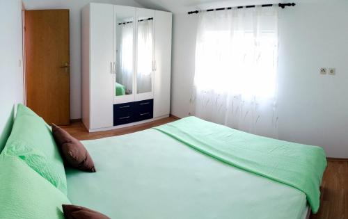 a bedroom with a large bed and a window at Olive Garden Apartments in Čilipi