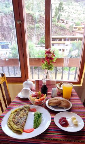 a table with plates of breakfast food on it at Hospedaje Chaska Pisac in Pisac