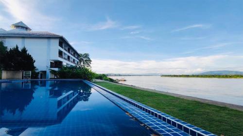a swimming pool with a view of a river at Siam Triangle Hotel in Chiang Saen