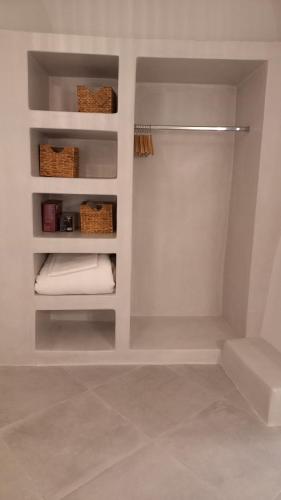 a bathroom with a walk in closet with towels and baskets at Cueva House in Vóthon