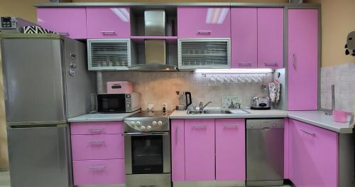 a kitchen with pink cabinets and a refrigerator at Beograd011 in Vračar (historical)