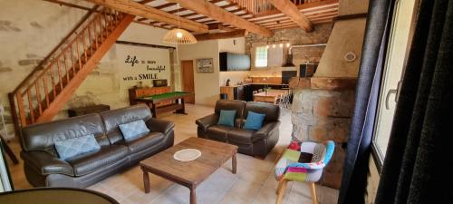 een woonkamer met een bank en een tafel bij La Grangette Grange rénovée 100m2 terrasse privative,10 min mer in Villeveyrac