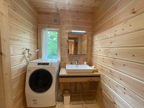 uma casa de banho com uma máquina de lavar roupa e um lavatório em 【moi】山中湖 新築フィンランドログハウス 大自然の中でBBQ可 em Yamanakako
