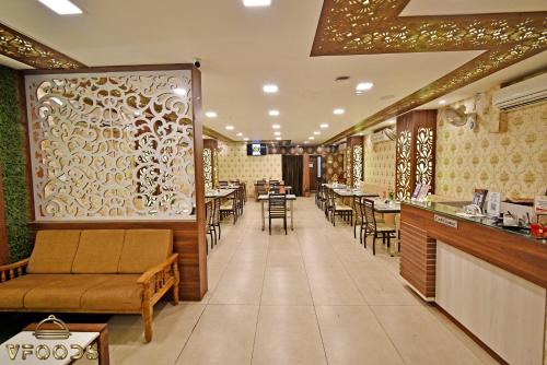 a restaurant with tables and chairs and a bar at Hotel Vi Park - City Centre in Puducherry