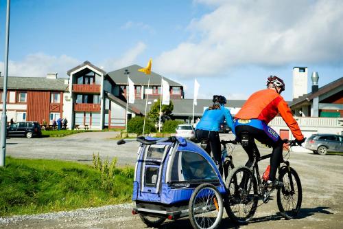 dos personas en bicicleta con un coche pequeño en Oset Fjellhotell, en Gol