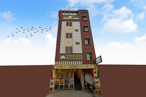 a building with a group of birds flying in the sky at Hotel Vi Park - City Centre in Puducherry