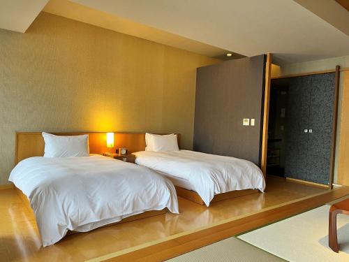 two beds in a hotel room with at ITSUKUSHIMA IROHA in Miyajima