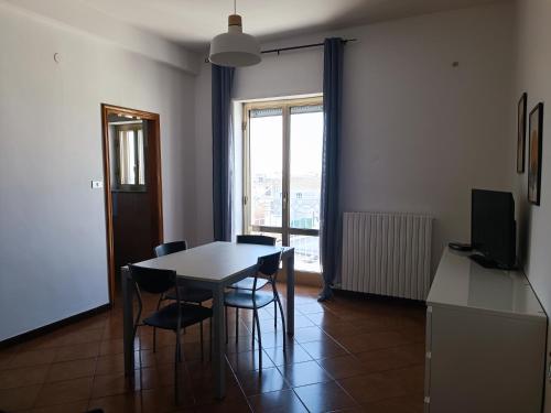 jadalnia ze stołem i krzesłami oraz oknem w obiekcie appartamento Alleria w mieście Laterza