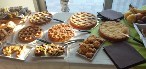 a table topped with pies and waffles and other desserts at La Rondanina in Castelnuovo Fogliani