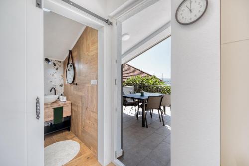 a kitchen and dining room with a clock on the wall at Miro guesthouse in Tivat