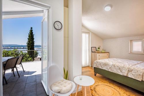 a bedroom with a bed and a balcony with a clock at Miro guesthouse in Tivat