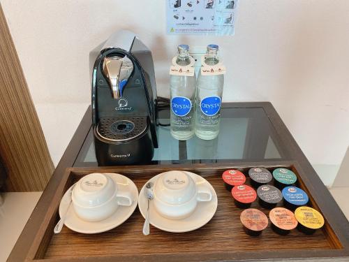 a tray with cups and plates and a blender and water at Siam Triangle Hotel Chiang Sean in Chiang Saen