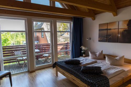 a bedroom with a bed and a balcony with a table at An der Metow-Ferienpark Hotel in Plau am See