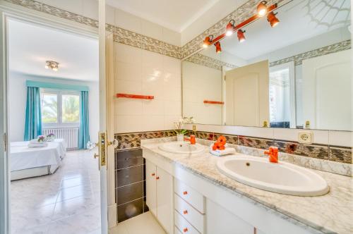 Un baño con dos lavabos y un espejo grande. en Ideal Property Mallorca - Casa Bonita, en Colonia de Campos