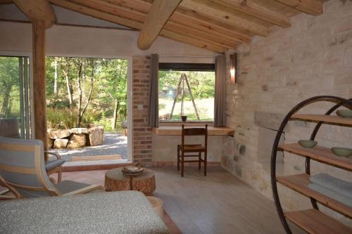 a living room with a large window and a table at Le doux refuge in Gagnières