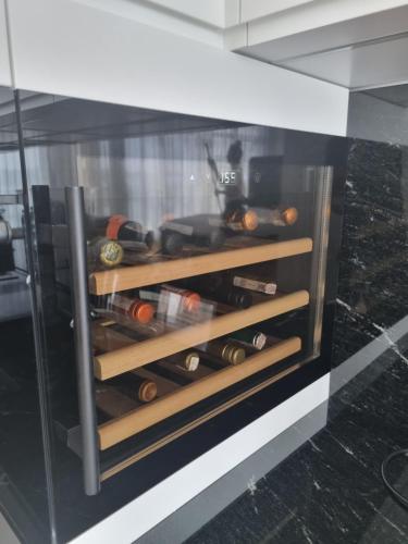 a glass cabinet filled with bottles of wine at Apartament z widokiem na jezioro in Charzykowy