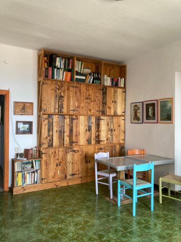 einen Tisch und Stühle in einem Zimmer mit einer Holzwand in der Unterkunft Occhj a Mari in Santa Teresa Gallura