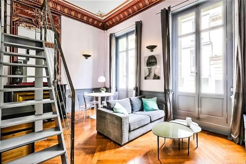 アヴィニョンにあるAppartement Chic & Baroque avec parking sécuriséのソファと階段のあるリビングルーム