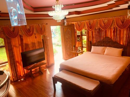 a bedroom with a bed and a television and a chandelier at Morning Walsh Resort in El Nido