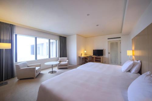 a hotel room with a large bed and a large window at ANA Crowne Plaza Kobe by IHG in Kobe