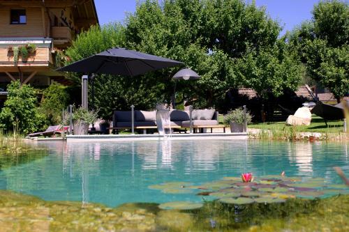 a pool with an umbrella and a table and chairs at THE MATTHEW - Copper Lodge in Wagrain
