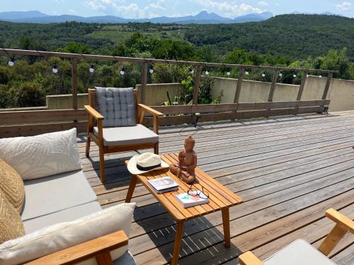 a deck with a couch and a coffee table at Villa Héliopolis in Ventiseri