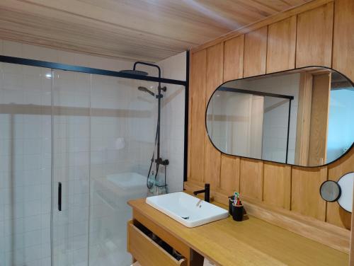 y baño con lavabo, espejo y ducha. en Apartamento mirador a las Islas Cíes en Cangas de Morrazo