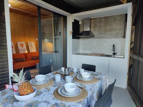 een tafel met een ananas en kopjes erop bij Apartamento mirador a las Islas Cíes in Cangas de Morrazo