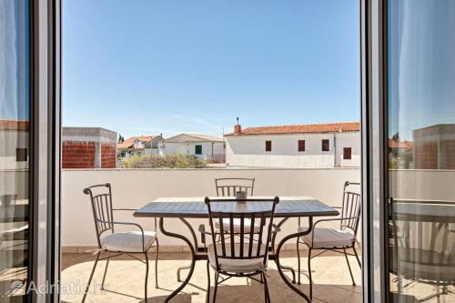 ein Tisch und Stühle auf einem Balkon in der Unterkunft Apartments Antea in Rogoznica