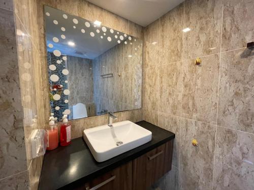 森林大道Grand Avenue Condo في باتايا سنترال: حمام مع حوض ومرآة