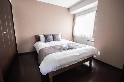 Fancy2 في سابورو: غرفة نوم مع سرير مع دبتين عليه