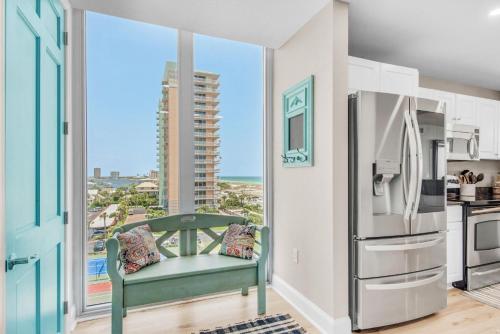 a kitchen with a refrigerator and a view of the ocean at Emerald Dolphin unit 610 in Pensacola Beach