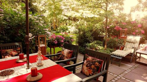 a patio with a table and chairs and flowers at Gastehaus HH- Winterhude in Hamburg