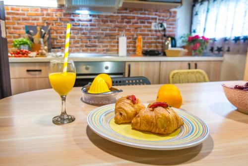 a table with a plate of croissants and a glass of orange juice at Boho House 3 in camp Terme Catez in Čatež ob Savi