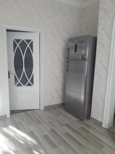 a refrigerator in a room next to a door at Apartment at Narimanov 151 in Ganja