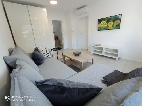 ein Wohnzimmer mit einem Sofa und einem Tisch in der Unterkunft Velobaltica apartmenty in Wisełka