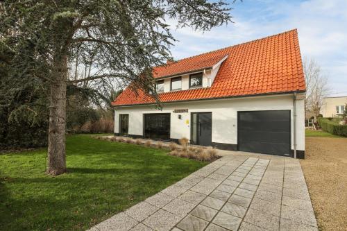 ein Haus mit einem orangenen Dach und einer Garage in der Unterkunft Villa De Strandjutter in Nieuwpoort