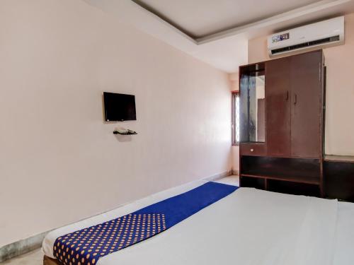 a bedroom with a bed and a tv on the wall at Hotel Cauvery in Visakhapatnam