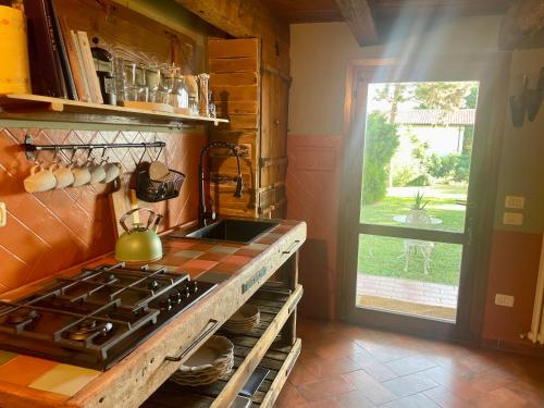 uma cozinha com um fogão, um lavatório e uma janela em FIG Cottage em Faenza