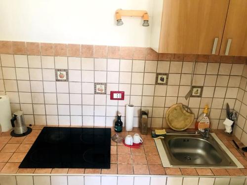 a kitchen with a sink and a tiled counter top at P4T Holidays Home - city center in Brindisi