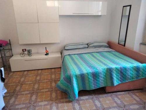 a bedroom with a bed with a colorful blanket on it at P4T Holidays Home - city center in Brindisi
